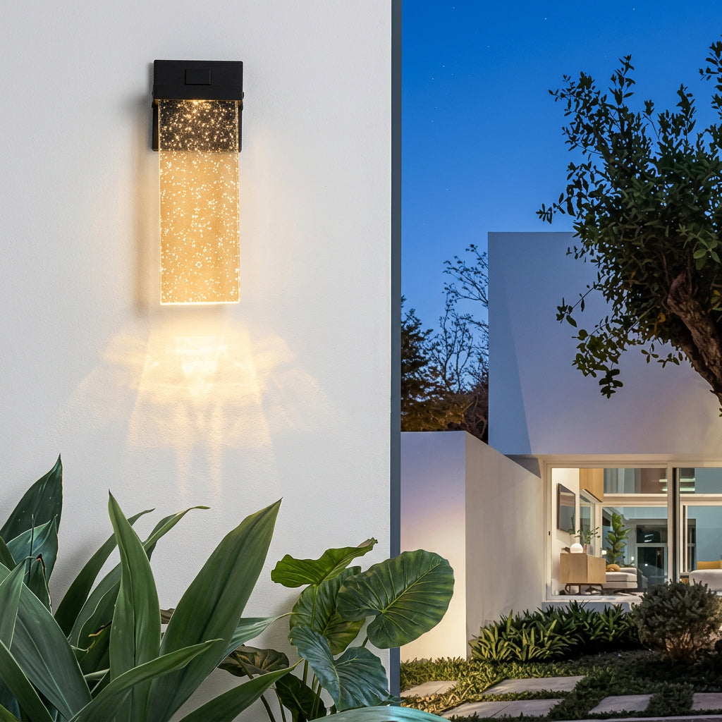 Close-up of a clear crystal-bubble style shade on a slim black outdoor wall light fixture.