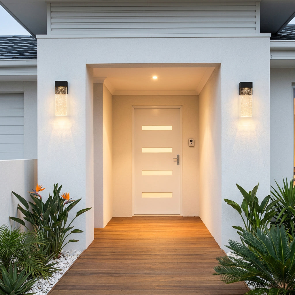 Matching black outdoor wall sconces with clear textured shades for a balanced look beside an entrance.