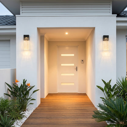 Matching black outdoor wall sconces with clear textured shades for a balanced look beside an entrance.